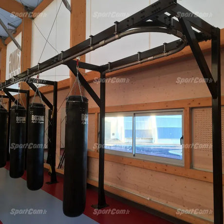 SportCom Förderschiene mit Rahmen für Sandsäcke, an einer Holzwand mit Fenster, vier Sandsäcke