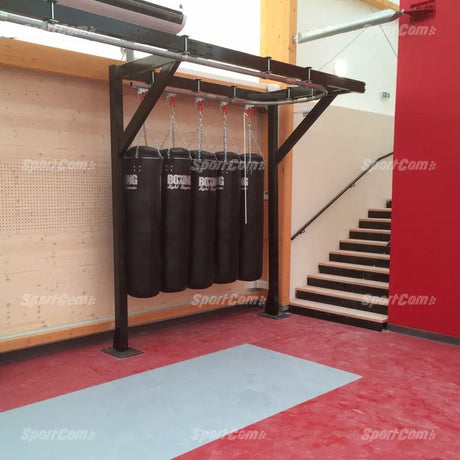 SportCom Förderschiene mit Rahmen für Sandsäcke, an einer Holzwand mit Treppe und rotem Boden