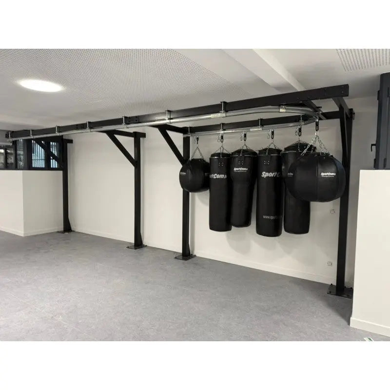 SportCom Förderschiene mit Rahmen für Sandsäcke, an einer weißen Wand mit Sandsäcken und Wassersäcken