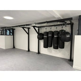 SportCom Förderschiene mit Rahmen für Sandsäcke, an einer weißen Wand mit Sandsäcken und Wassersäcken