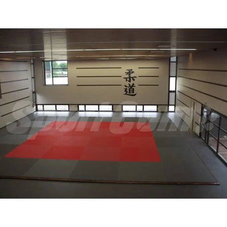 SportCom Judo-Tatami Reisstroh 1 × 1 m, 5 cm, rutschfeste Unterseite, rote Fläche mit dunklem Rand vor Wand mit Schriftzeichen