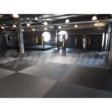 SportCom Judo-Tatami Reisstroh 1 × 1 m, 5 cm, rutschfeste Unterseite, dunkle Fläche mit Boxring im Hintergrund