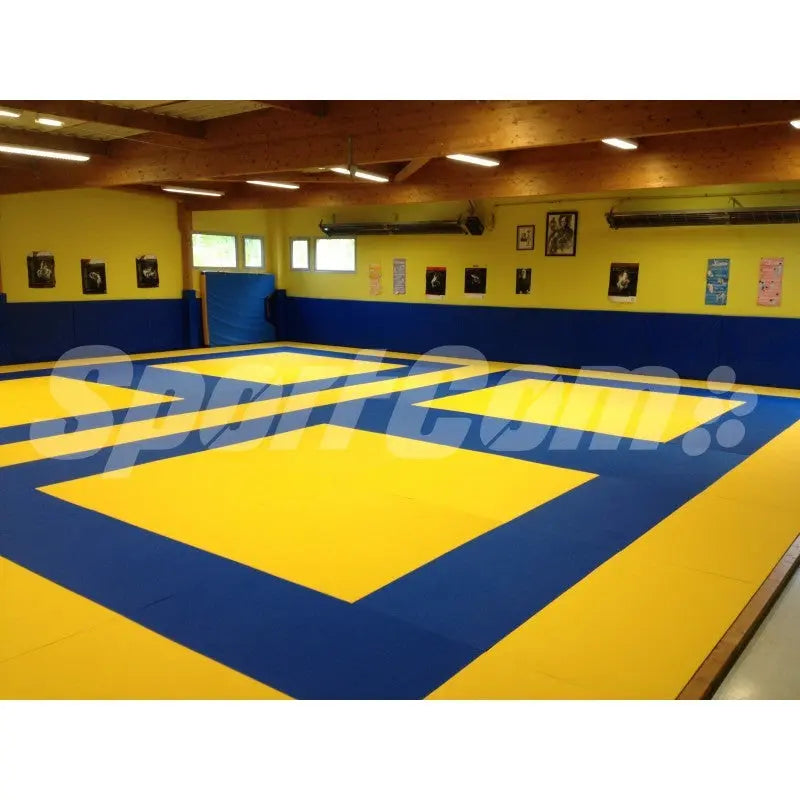 SportCom Judo-Tatami Reisstroh 2 × 1 m, 5 cm, glatte Unterseite, zwei gelbe Kampfzonen auf Blau im Dojo mit Bildern an der Wand