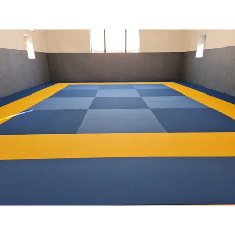 SportCom Judo-Tatami Reisstroh 2 × 1 m, 5 cm, glatte Unterseite, blaues Schachbrettmuster mit gelbem Rand in heller Halle