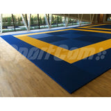 SportCom Judo-Tatami Reisstroh 2 × 1 m, 5 cm, glatte Unterseite, blau-gelbe Fläche auf Parkett vor einer Fensterfront