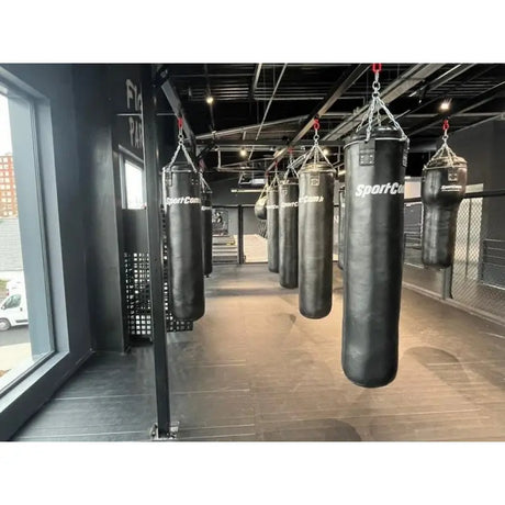 SportCom Kunstleder-Sandsack 1,80 m mehrere Säcke an Deckenträgern, Blick entlang der Reihe