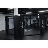SportCom MMA-Käfig-Individualisierung: schwarzer Käfig mit Logo-Polstern, seitliche Ansicht in der Halle