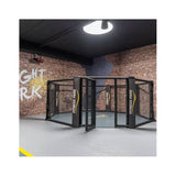 SportCom MMA-Käfig-Individualisierung: kompakter Käfig mit offener Tür vor Backsteinwand mit Wandschrift