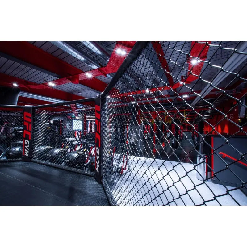 SportCom MMA-Käfig-Individualisierung: Blick durch das Käfiggitter mit roter Deckenbeleuchtung