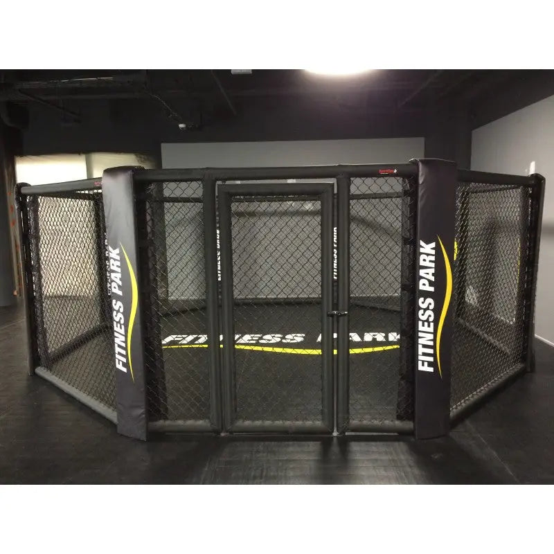 SportCom MMA-Käfig-Individualisierung: schwarzer Käfig mit gelbem Schriftzug auf Polstern und Schürze