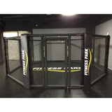 SportCom MMA-Käfig-Individualisierung: schwarzer Käfig mit gelbem Schriftzug auf Polstern und Schürze