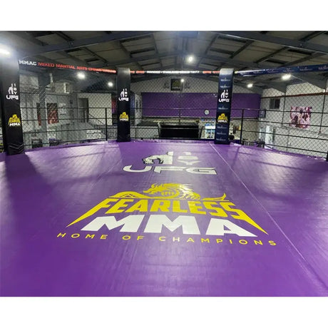 SportCom MMA-Käfig-Individualisierung: lila Bodenfläche mit gelbem Logo-Druck in einer großen Trainingshalle