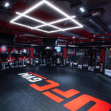 SportCom MMA-Käfig-Individualisierung: schwarzer Boden mit großem roten Schriftzug in einem Studio