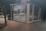 SportCom MMA-Käfig Oktagon zur Bodenmontage, in einem dunklen Raum, Blick durch das Maschengeflecht
