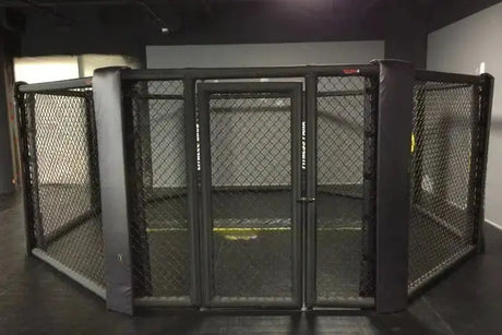 SportCom MMA-Käfig Oktagon zur Bodenmontage, frontal auf die Tür in einem dunklen Studio