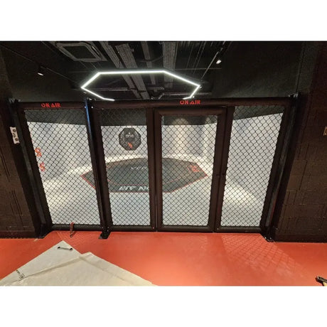 SportCom MMA-Paneel mit Tür als Käfigfront mit Lichtring über rotem Boden, frontal