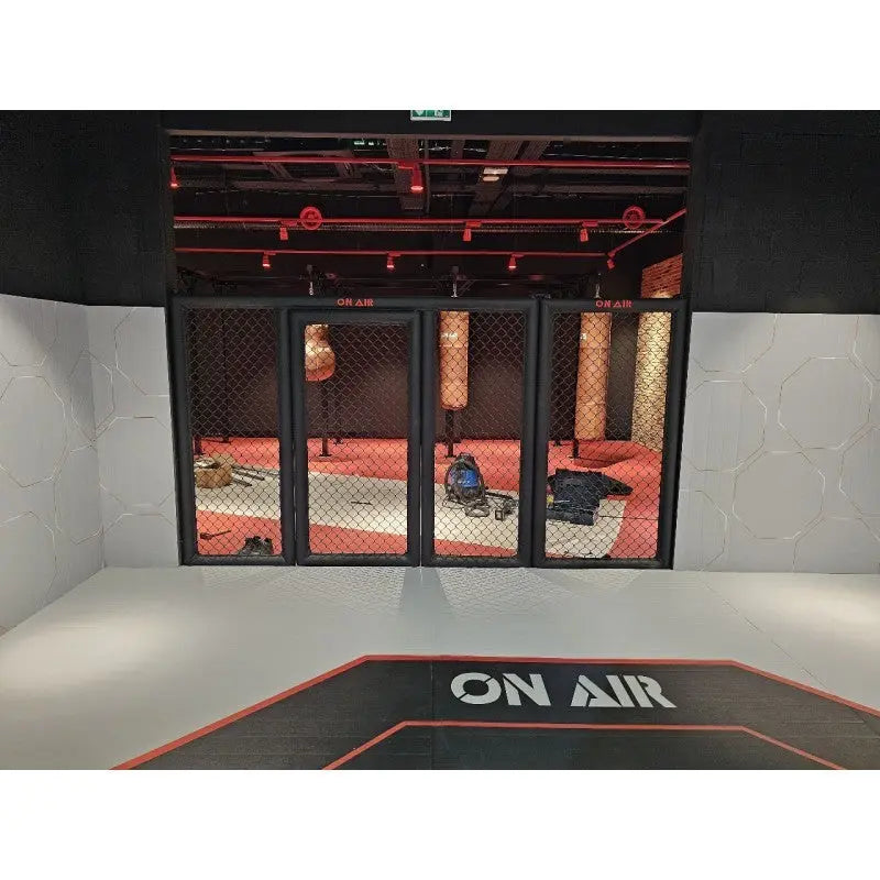 SportCom MMA-Paneel mit Tür hinter einer Bodenmatte vor rot beleuchteter Halle