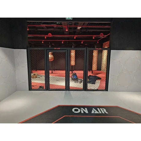 SportCom MMA-Paneel mit Tür hinter einer Bodenmatte vor rot beleuchteter Halle