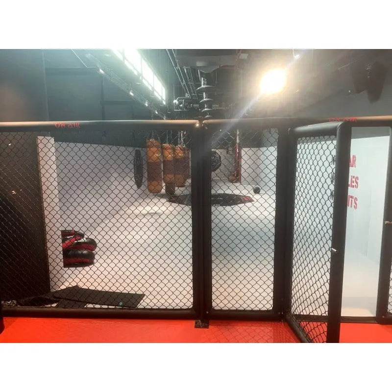 SportCom MMA-Paneel mit Tür mit geöffneter Tür auf rotem Boden und Boxsäcken dahinter