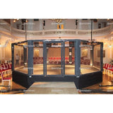SportCom MMA-Trainingskäfig mit Podium, in einem festlichen Saal mit Stuhlreihen