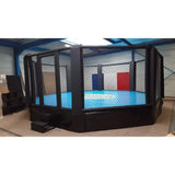 SportCom MMA-Trainingskäfig mit Podium, mit blauer Matte in einer hellen Halle