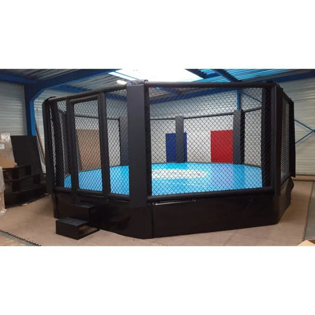 SportCom MMA-Trainingskäfig mit Podium, mit blauer Matte in einer hellen Halle