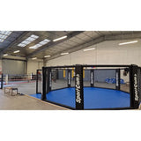 SportCom MMA-Trainingskäfig zur Bodenmontage, mit blauem Boden in einer Lagerhalle
