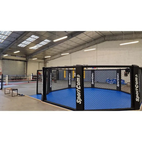 SportCom MMA-Trainingskäfig zur Bodenmontage, mit blauem Boden in einer Lagerhalle