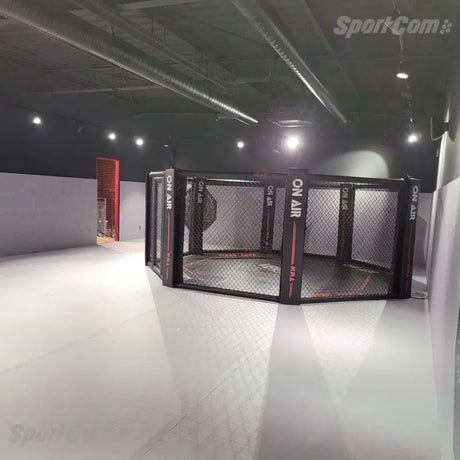 SportCom MMA-Trainingskäfig zur Bodenmontage, in einer Halle mit Lichtkegel von oben, schräg