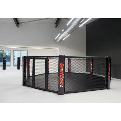 SportCom MMA-Trainingskäfig zur Bodenmontage, in einer weißen Halle mit Boxsack im Hintergrund
