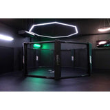 SportCom MMA-Trainingskäfig zur Bodenmontage, in einem dunklen Studio mit grünem Licht und Lichtring