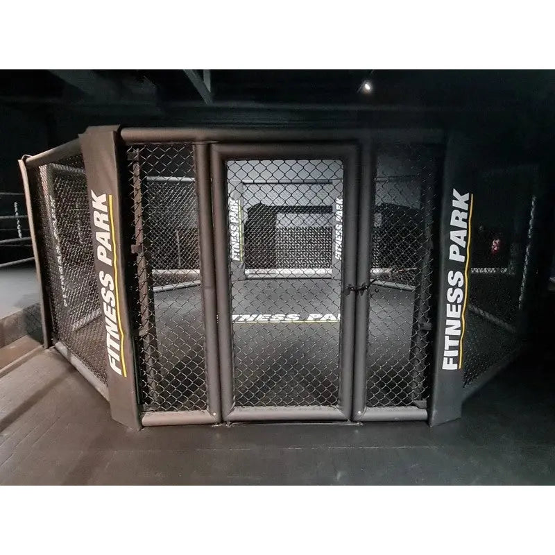 SportCom MMA-Trainingskäfig zur Bodenmontage, Tür mit bedruckten Pfosten im dunklen Studio, frontal