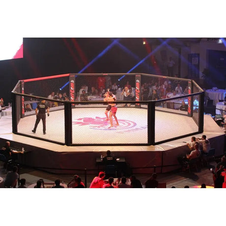 SportCom MMA-Wettkampfkäfig 7 m mit 9-m-Laufsteg, während eines Kampfes mit roter Bühnenbeleuchtung
