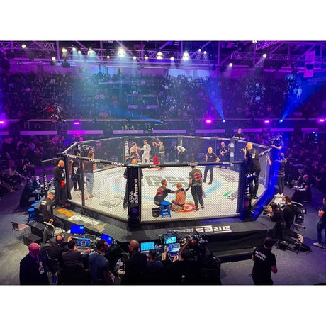 SportCom MMA-Wettkampfkäfig 7 m mit 9-m-Laufsteg, bei einem Event mit Zuschauern und Kamerateam