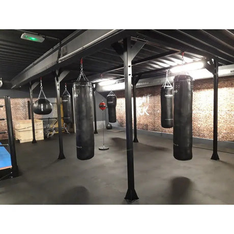 SportCom Modulare Sandsack-Station, in einem Gym mit Backsteinwand, schräg von vorn