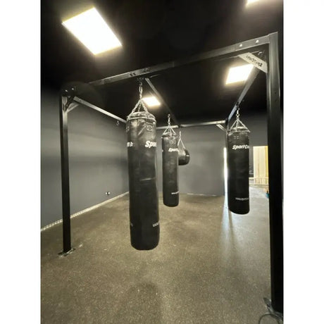 SportCom Modulare Sandsack-Station, in einem dunklen Raum mit Deckenlicht, frontal