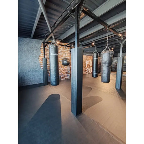 SportCom Modulare Sandsack-Station, in einem Gym mit Backsteinwand, Hochformat