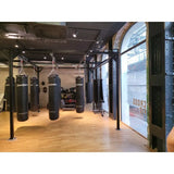SportCom Modulare Sandsack-Station, in einem Gym mit Rundbogenfenster und Parkett