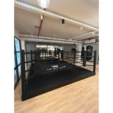 SportCom Pro-Trainingsboxring mit 30 cm Podium, mit Club-Logo auf Holzboden, Schrägansicht