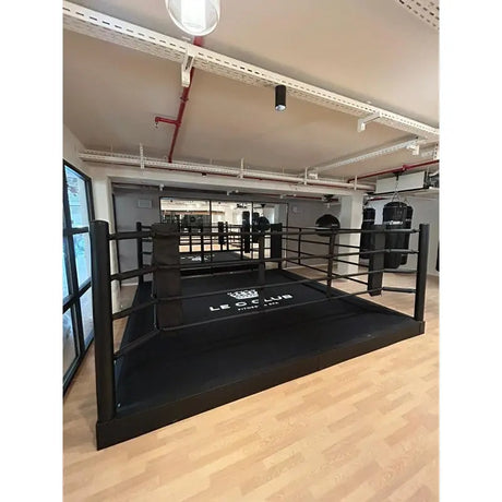 SportCom Pro-Trainingsboxring mit 30 cm Podium, mit Club-Logo auf Holzboden, Schrägansicht