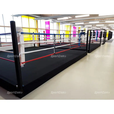 SportCom Pro-Trainingsboxring mit 30 cm Podium, in einer langen Halle mit mehreren Ringen