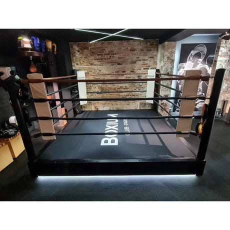 SportCom Pro-Trainingsboxring mit 30 cm Podium, mit LED-Licht am Podium vor Backsteinwand