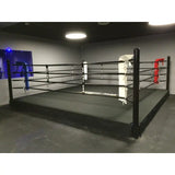 SportCom Pro-Trainingsboxring mit 30 cm Podium, in einem dunklen Studio mit Rundleuchte, Seitenansicht