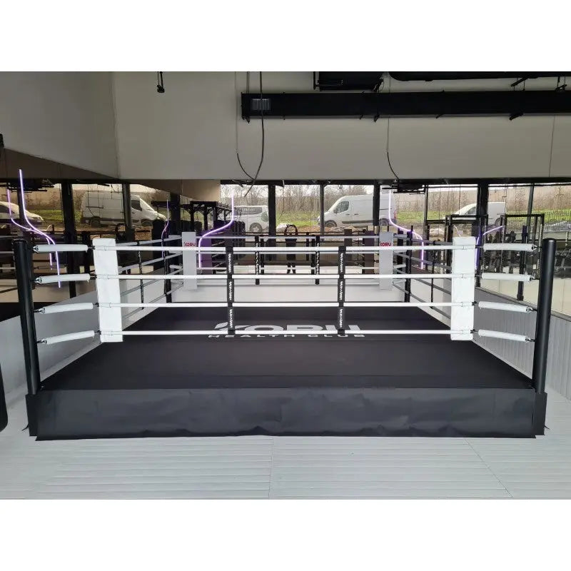 SportCom Pro-Trainingsboxring mit 50 cm Podium, in einer Halle vor Fensterfront, frontal