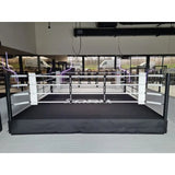 SportCom Pro-Trainingsboxring mit 50 cm Podium, in einer Halle vor Fensterfront, frontal