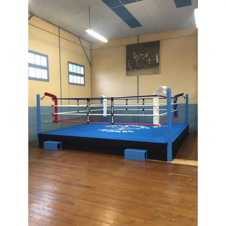 SportCom Pro-Trainingsboxring mit 50 cm Podium, mit blauem Boden in einer Halle mit Holzboden