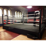 SportCom Pro-Trainingsboxring mit 50 cm Podium, in einer Halle mit Rundbogenfenstern