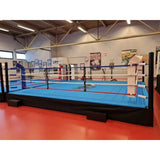 SportCom Pro-Trainingsboxring mit 50 cm Podium, mit blauem Boden, Seitenansicht in der Halle