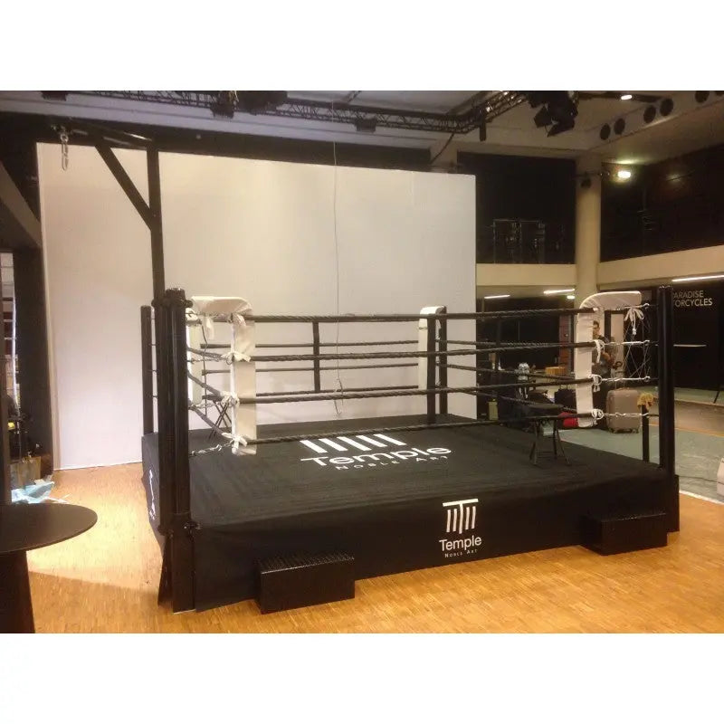 SportCom Pro-Trainingsboxring mit 50 cm Podium, mit schwarzem Boden und Logo, schräg von vorn