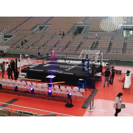 SportCom Pro-Wettkampf-Boxring mit 1 m Podium, in einer Arena beim Aufbau mit Besuchern